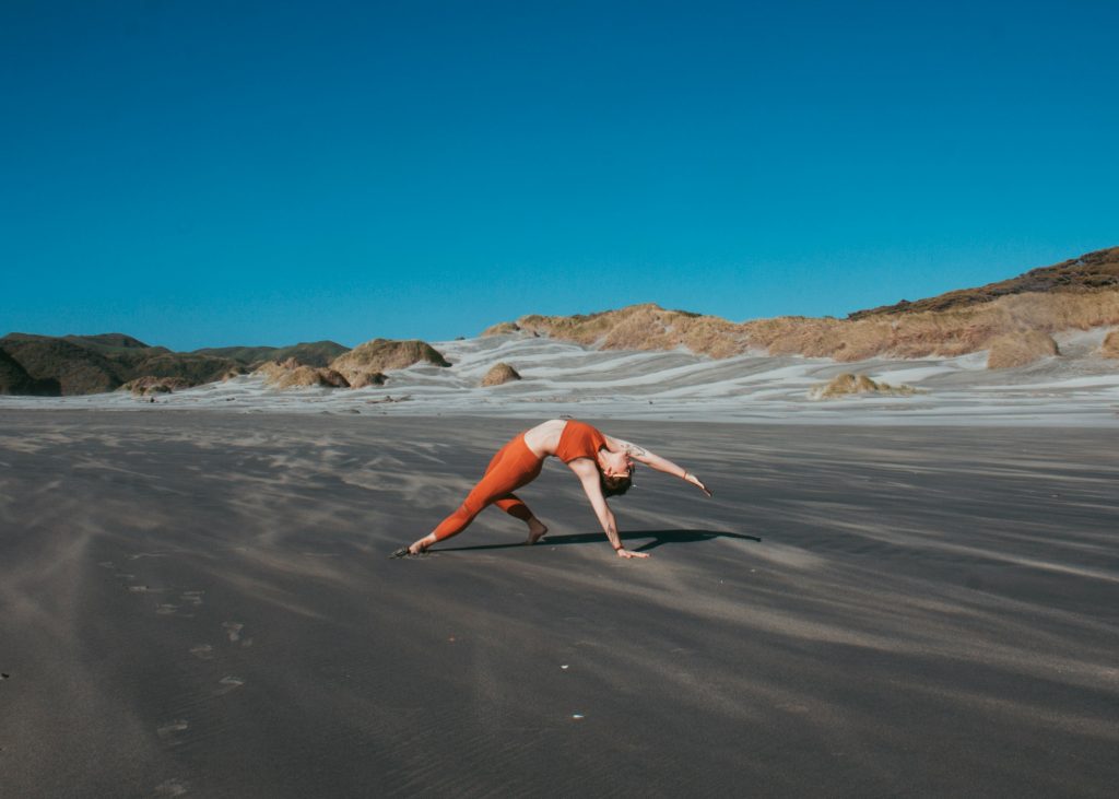 girl doing yoga at the beach